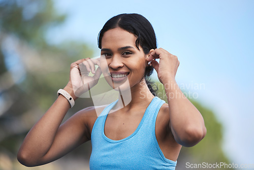 Image of Fitness, woman and portrait smile with earphones for running, exercise or cardio workout in nature. Happy fit female runner smiling and listening to music on earpieces for audio track and exercising