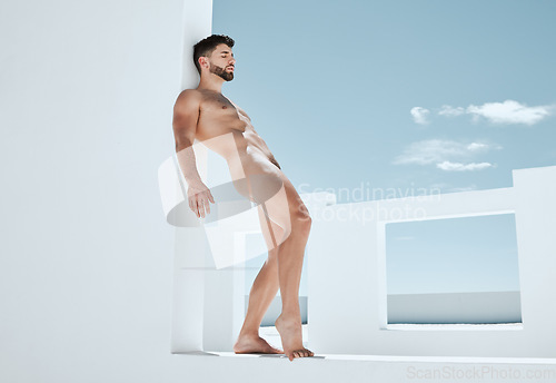 Image of Creative, carefree and a man in the nude by a building for fantasy, freedom and handsome. Pose, art and a naked model standing by a wall in summer while attractive, sensual and seductive in nudity