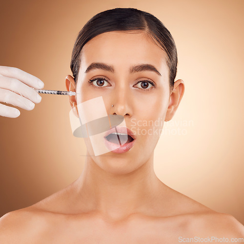 Image of Plastic surgery surprise, hands or woman face with needle facial change, spa cosmetics process or studio skincare. Wow, medical injection or portrait female with aesthetic beauty on brown background