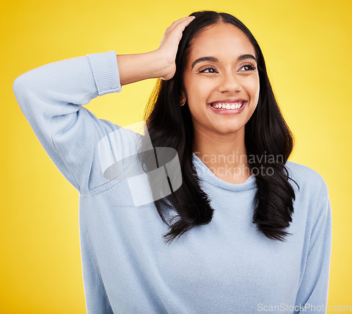 Image of Thinking, smile and a woman on a yellow background in studio contemplating a happy memory. Idea, vision and mindset with an attractive young female looking thoughtful about the distant future