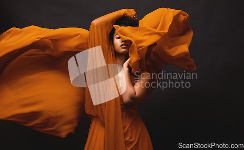 Image of Black woman, art and fashion, fabric movement on dark background with beauty and aesthetic motion. Flowing silk, fantasy and artistic, serious African model in brown creative designer dress in studio