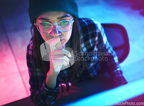 Image of Cyber security, focus and woman hacker working on a computer in the basement at night for phishing. Database, password and ransomware with a female coder hacking a digital transformation network