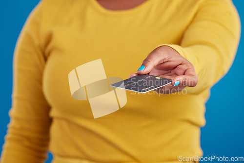 Image of Credit card, payment and woman hand in a studio ready for finance expenses and sales. Isolated, blue background and paying with a female model showing financial banking method for ecommerce sale