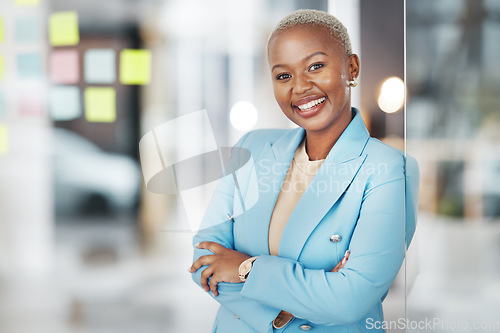 Image of Black woman, portrait smile and arms crossed in small business management leaning proud on glass at office. Happy African American female smiling in confidence for corporate planning at workplace
