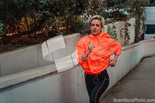 Image of Women in sports clothes running in a modern urban environment et night time. The concept of a sporty and healthy lifestyle