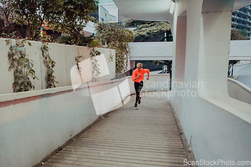 Image of Women in sports clothes running in a modern urban environment et night time. The concept of a sporty and healthy lifestyle