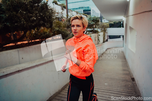 Image of Women in sports clothes running in a modern urban environment et night time. The concept of a sporty and healthy lifestyle