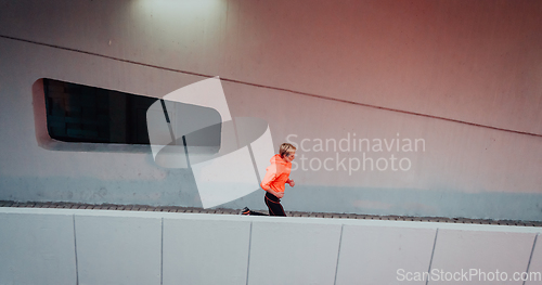 Image of Women in sports clothes running in a modern urban environment et night time. The concept of a sporty and healthy lifestyle