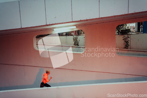 Image of Women in sports clothes running in a modern urban environment et night time. The concept of a sporty and healthy lifestyle