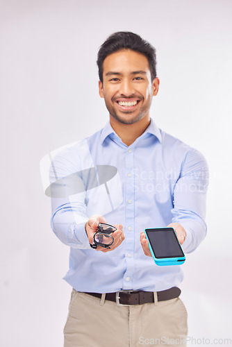 Image of Portrait, ecommerce and glasses with a man in studio on a gray background to offer pos payment for eye care. Happy, smile with an agent marketing while holding a wireless finance device and eyewear