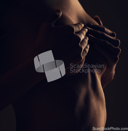 Image of Breast, hands and woman silhouette dark background of skin, body and model with glow, light and art on black. Chest of aesthetic person in studio for abstract, creativity and shadow profile or space
