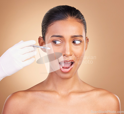 Image of Woman, needle and face in studio with fear of pain with cosmetics, surgery and brown background. Young, model and syringe for facial cosmetic and collagen filler for skincare, dermatology and change