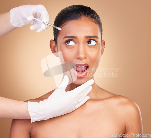 Image of Woman, syringe and shock face in studio for cosmetic, surgery or wow for pain in forehead by background. Young, model and needle for facial skin, cosmetics and collagen filler for dermatology change