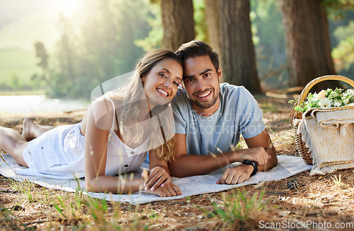 Image of Couple on picnic, portrait and relax together in nature park, happy people with travel and bonding outdoor. Happiness, man and woman lying down and commitment with trust and love in relationship