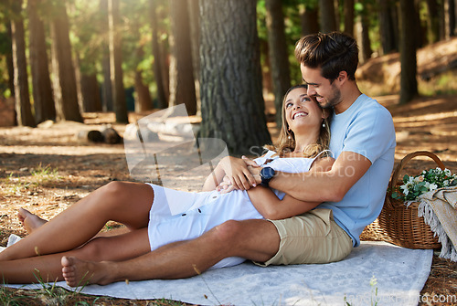 Image of Couple on picnic, cuddle and happy relationship with love and trust, travel and adventure in nature park. Young people in forest, outdoor and happiness together with smile, commitment and care