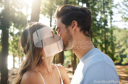 Image of Couple kiss in forest, love and summer with freedom and adventure, affection in relationship and care outdoor. People together in nature park, commitment and trust with romance, content and sunshine