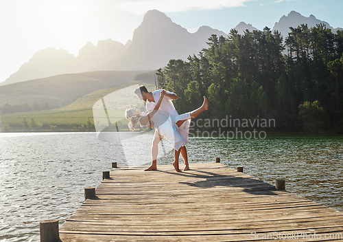 Image of Love, lake and couple dancing together on the pier while on a romantic vacation, adventure or holiday. Romance, dance and young and and woman on a sidewalk in nature while on a summer weekend trip.