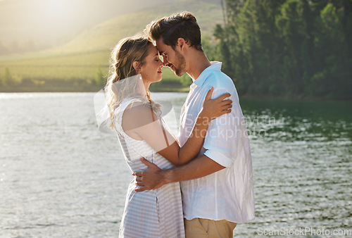 Image of Couple, head touch and hug by lake for outdoor date, romantic adventure and summer love in nature. Man, woman and romance with embrace, care and bond by water with sunshine, freedom and happiness