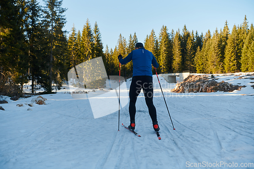 Image of Nordic skiing or Cross-country skiing classic technique practiced by man in a beautiful panoramic trail at morning.Selective focus.