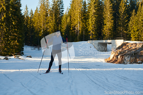 Image of Nordic skiing or Cross-country skiing classic technique practiced by man in a beautiful panoramic trail at morning.Selective focus.