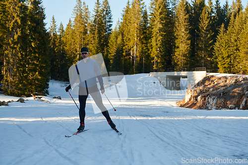 Image of Nordic skiing or Cross-country skiing classic technique practiced by man in a beautiful panoramic trail at morning.Selective focus.