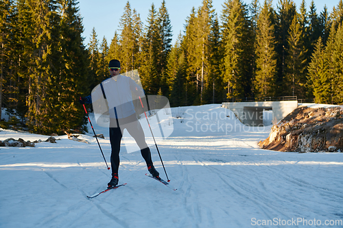 Image of Nordic skiing or Cross-country skiing classic technique practiced by man in a beautiful panoramic trail at morning.Selective focus.