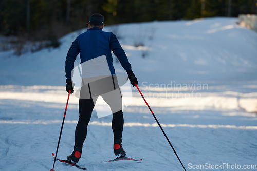 Image of Nordic skiing or Cross-country skiing classic technique practiced by man in a beautiful panoramic trail at morning.Selective focus.