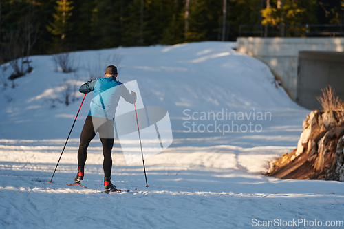 Image of Nordic skiing or Cross-country skiing classic technique practiced by man in a beautiful panoramic trail at morning.Selective focus.