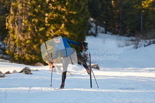 Image of Nordic skiing or Cross-country skiing classic technique practiced by man in a beautiful panoramic trail at morning.Selective focus.