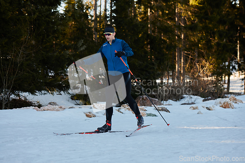 Image of Nordic skiing or Cross-country skiing classic technique practiced by man in a beautiful panoramic trail at morning.Selective focus.