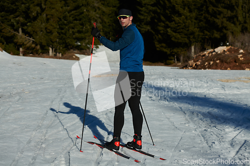 Image of Nordic skiing or Cross-country skiing classic technique practiced by man in a beautiful panoramic trail at morning.Selective focus.