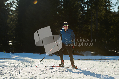 Image of Nordic skiing or Cross-country skiing classic technique practiced by man in a beautiful panoramic trail at morning.Selective focus.