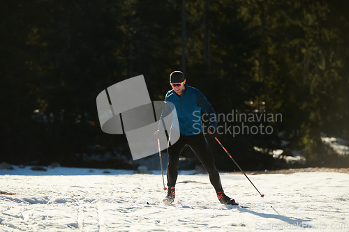 Image of Nordic skiing or Cross-country skiing classic technique practiced by man in a beautiful panoramic trail at morning.Selective focus.