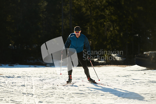 Image of Nordic skiing or Cross-country skiing classic technique practiced by man in a beautiful panoramic trail at morning.Selective focus.