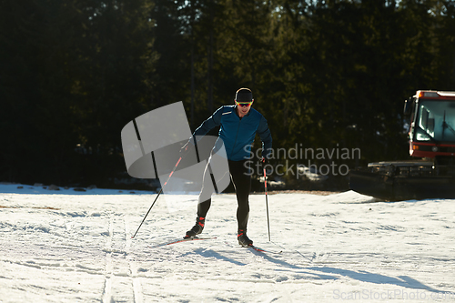 Image of Nordic skiing or Cross-country skiing classic technique practiced by man in a beautiful panoramic trail at morning.Selective focus.