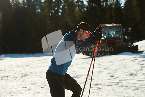 Image of Nordic skiing or Cross-country skiing classic technique practiced by man in a beautiful panoramic trail at morning.Selective focus.