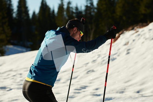 Image of Nordic skiing or Cross-country skiing classic technique practiced by man in a beautiful panoramic trail at morning.Selective focus.