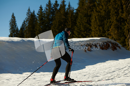 Image of Nordic skiing or Cross-country skiing classic technique practiced by man in a beautiful panoramic trail at morning.Selective focus.