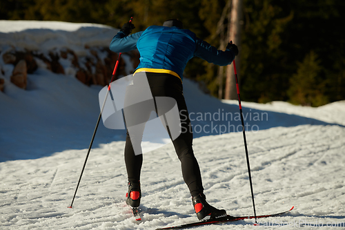 Image of Nordic skiing or Cross-country skiing classic technique practiced by man in a beautiful panoramic trail at morning.Selective focus.