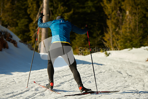 Image of Nordic skiing or Cross-country skiing classic technique practiced by man in a beautiful panoramic trail at morning.Selective focus.