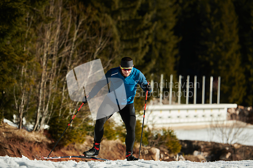 Image of Nordic skiing or Cross-country skiing classic technique practiced by man in a beautiful panoramic trail at morning.Selective focus.