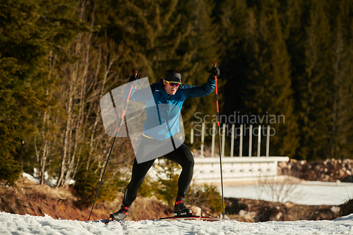 Image of Nordic skiing or Cross-country skiing classic technique practiced by man in a beautiful panoramic trail at morning.Selective focus.