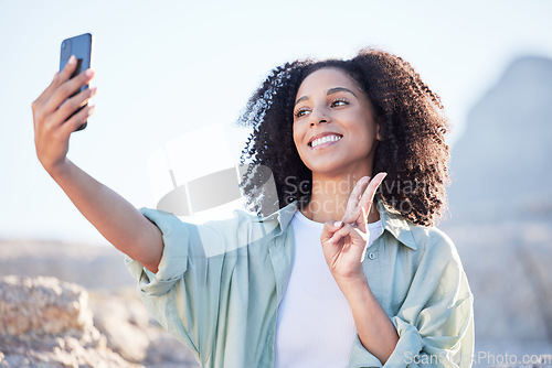 Image of Woman at beach, selfie and peace hand sign, happy with travel and lifestyle influencer, photography and social media. Post, content creation and female person smile in picture outdoor with adventure