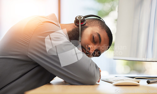 Image of Black man, sleeping on desk and tired call center employee, insomnia or mental health problem with headset and mic. Burnout, fatigue and male consultant with stress, nap at work with customer service