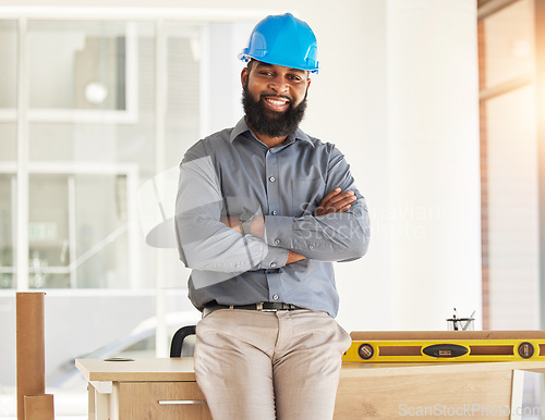 Image of Engineering, crossed arms and portrait of male construction worker with confidence in his office. Happy, smile and African man industrial professional standing by a desk in industry building on site.