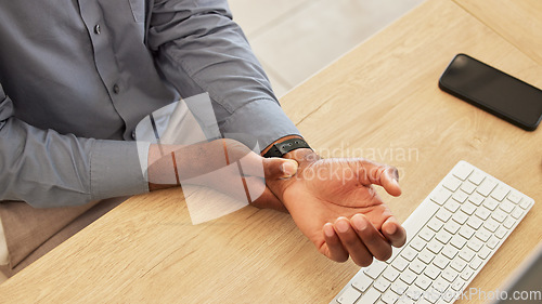 Image of Hand, wrist pain and a business black man at his desk in the office with an injury while working on a keyboard. Arthritis, injury or carpal tunnel with an employee sitting at his workplace from above