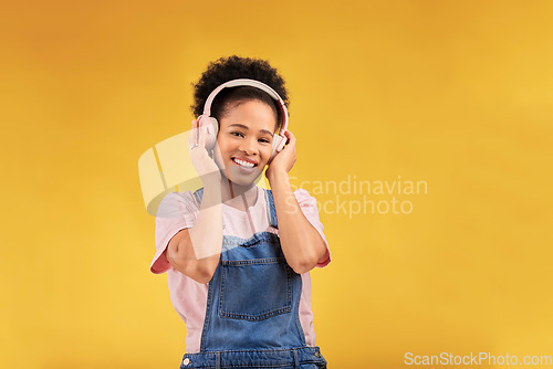 Image of Headphones, music and black woman in portrait, smile and isolated in studio on a yellow background mockup space. Face, happy and person listening to radio, podcast or sound for jazz, hip hop or audio