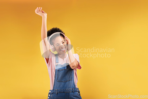 Image of Headphones, music and happy black woman dance in studio isolated on a yellow background mockup space. African person, smile and listen to radio, podcast or sound for jazz, hip hop or streaming audio