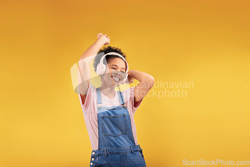 Image of Music, headphones and happy black woman, dancing and isolated in studio on a yellow background mockup space. African person, smile and listening to radio, podcast or sound for jazz, hip hop or audio