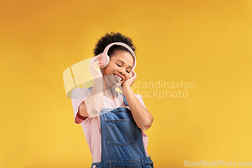 Image of Music, headphones and happy black woman listening in studio isolated on a yellow background mockup space. African person, smile or hearing radio, podcast or sound for jazz, hip hop or streaming audio